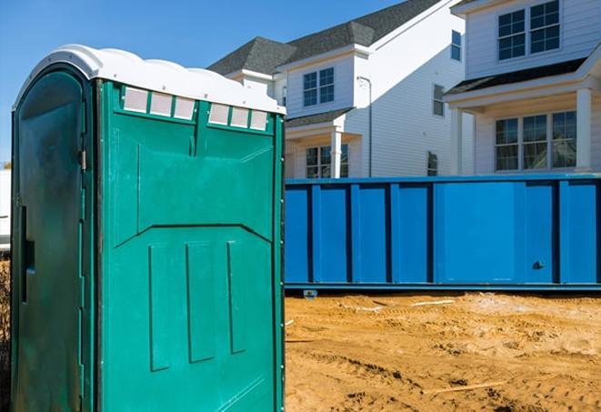 a row of blue and white portable toilets on a busy construction site